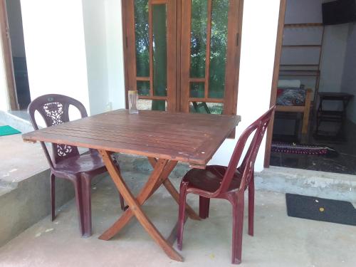 a wooden table and two chairs sitting around it at Wilpattu national park forest buma lodge in Pahala Maragahawewa