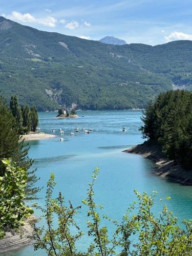 a large blue river with boats in the water at Appartement 4 couchages avec terrasse et local à vélos in Ancelle