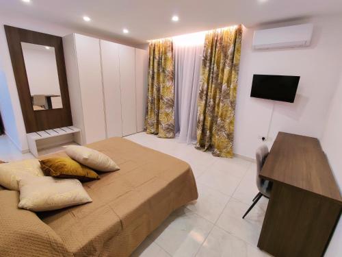 a bedroom with a bed and a desk and a mirror at Diamond Residence Qawra - Side Sea View in St Paul's Bay