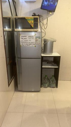 lodówka z kuchenką mikrofalową na górze w pokoju w obiekcie cebu hostel w Hongkongu