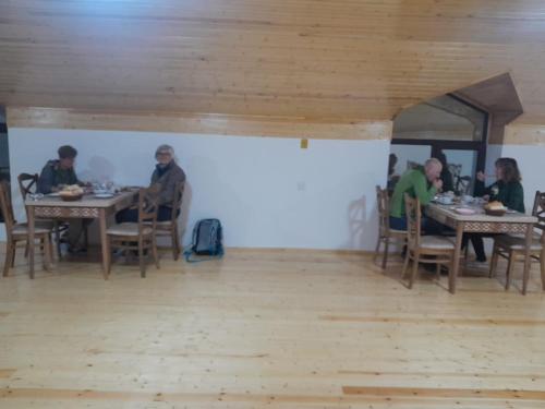 a group of people sitting at tables in a room at Lahij Rashad Ismayilov Hotel in Lahıc