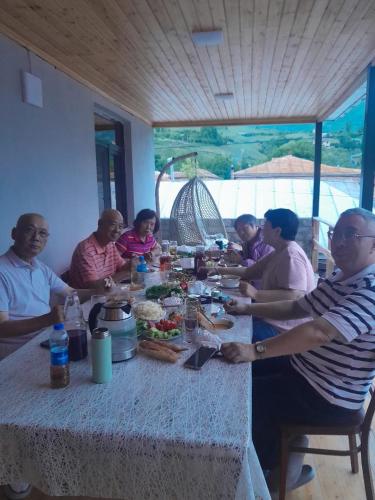 a group of people sitting around a table eating food at Lahij Rashad Ismayilov Hotel in Lahıc