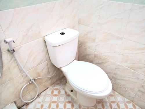 a bathroom with a toilet and a shower at Sartika Hotel Mitra RedDoorz Pati in Pati