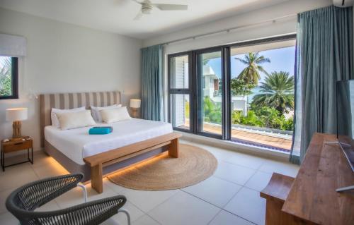 a bedroom with a bed and a large window at Beachfront Villa Private Pool and Beach in Tamarin
