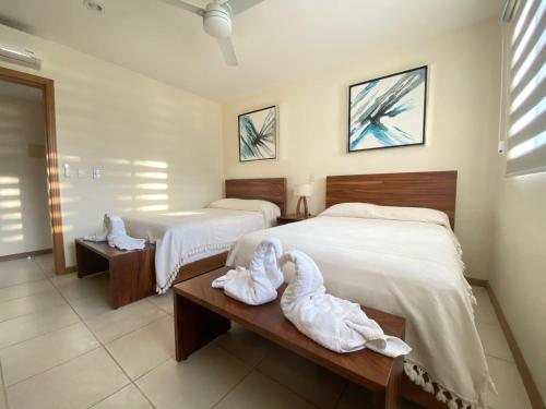 a bedroom with two beds with towels on a bench at Nuevo Vallarta flamingos beach en bahia de banderas in Nuevo Vallarta