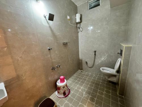 a bathroom with a shower with a toilet and a sink at Sakthimurugan residency in Erode