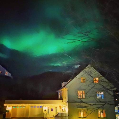 an image of the northern lights in the sky over a house at 1. etg i Dampskipsbrygga, Lødingen havn in Lødingen
