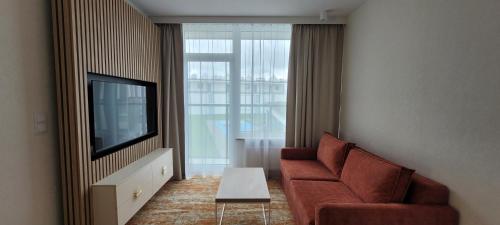 un salon avec un canapé et une télévision dans l'établissement Bel Mare Aqua, à Międzyzdroje