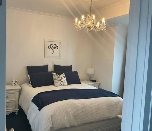 a bedroom with a large bed and a chandelier at Villas de Lago Central Hamilton in Hamilton