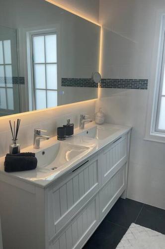 a white bathroom with two sinks and a mirror at Villas de Lago Central Hamilton in Hamilton