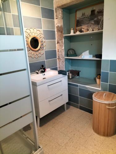 une salle de bain avec un lavabo et un miroir dans l'établissement L'esprit de famille, à Semur-en-Auxois
