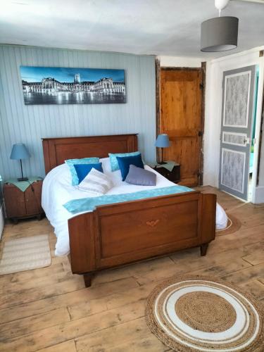 une chambre avec un grand lit avec des oreillers bleus dans l'établissement L'esprit de famille, à Semur-en-Auxois