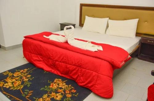 a bed with red sheets and white socks on it at The Cinnamon Villa By Kings Bay in Negombo