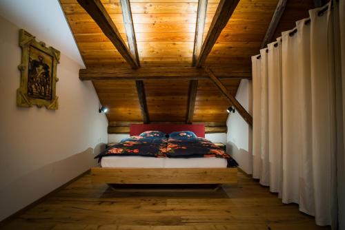 a bed in a room with a wooden ceiling at Hayrack Skok Mozirje in Mozirje