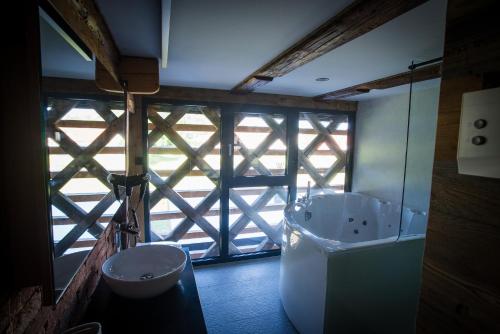a bathroom with a large window and a tub at Hayrack Skok Mozirje in Mozirje