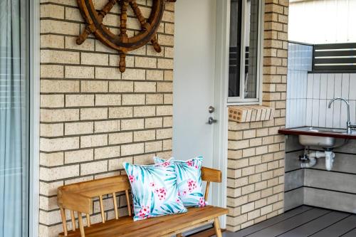 a wooden bench with two pillows on a porch at Shepherds Delight-Access Friendly-Linen Included in Goolwa South