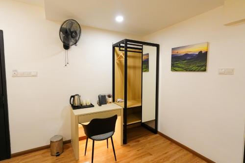 a room with a desk and a fan and a mirror at Merits Hotel Cameron Highlands in Cameron Highlands