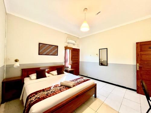 a bedroom with a bed and a mirror on the wall at Wisma Anugerah Redpartner Near Masjid Zayed Solo in Bonorejo