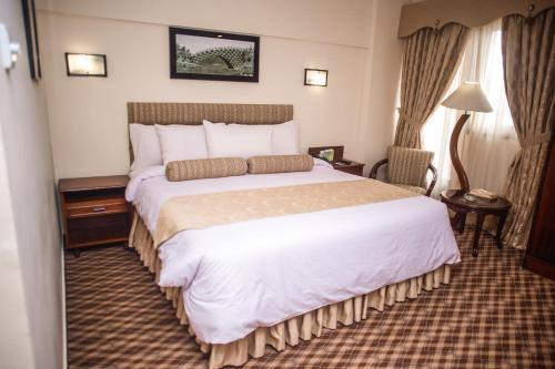 a bedroom with a large bed in a hotel room at Mehran Hotel Karachi in Karachi
