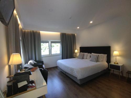 a hotel room with a bed and a chair at Casa do Rio in Termas de Sao Pedro do Sul