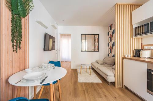 un salon avec une table blanche et un canapé dans l'établissement MM Suites Saint-Remi, à Reims