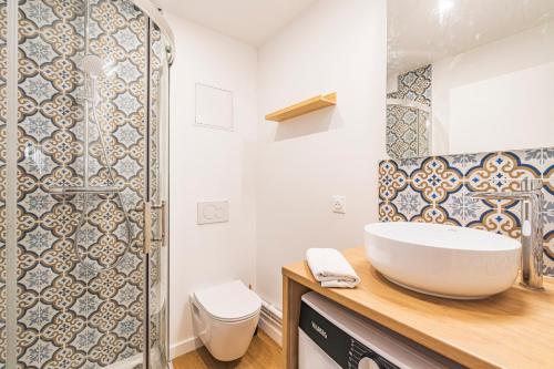 une salle de bain avec un lavabo et des toilettes dans l'établissement MM Suites Saint-Remi, à Reims