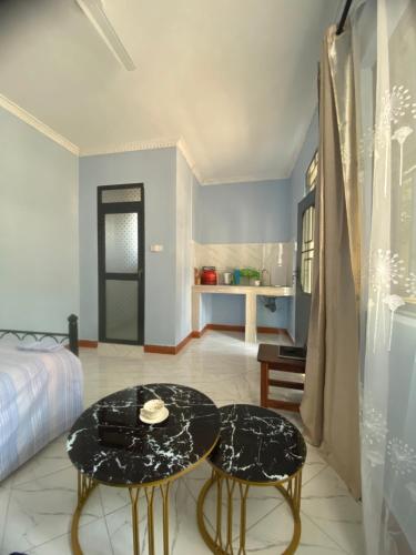 a bedroom with a bed and a table and two stools at Anne studio & Home stay in Mwanza