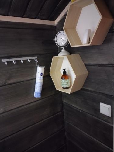 a clock and a bottle in a box on a wall at Ruka Star in Ruka