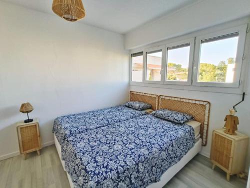 une chambre avec un lit et deux fenêtres dans l'établissement Le Coquet T2 à 50 m de la mer, à Saint-Raphaël