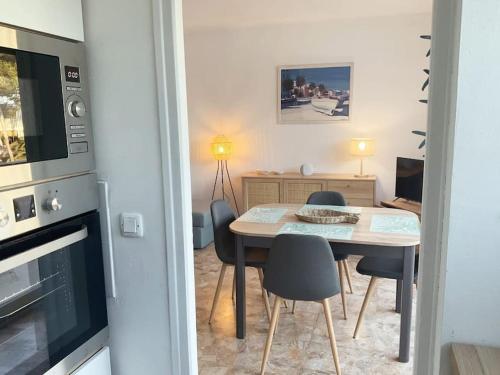 une salle à manger avec une table et des chaises et une cuisine dans l'établissement Le Coquet T2 à 50 m de la mer, à Saint-Raphaël