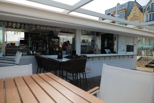 a restaurant with a table and chairs on a patio at Hôtel Merveilleux Côté Mer in Dunkerque