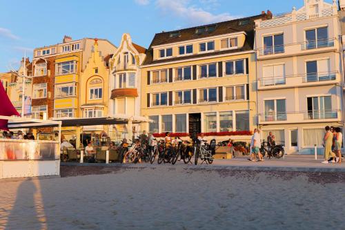 a group of buildings and people walking on a street at Hôtel Merveilleux Côté Mer in Dunkerque