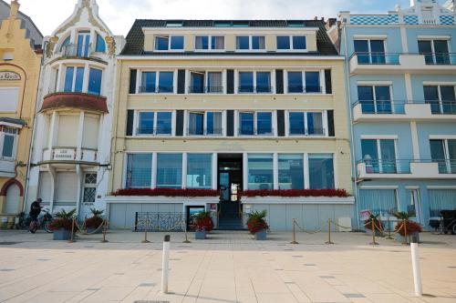a building in a city with flowers in front of it at Hôtel Merveilleux Côté Mer in Dunkerque