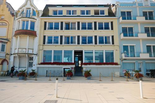 a large building with windows and plants in a courtyard at Hôtel Merveilleux Côté Mer in Dunkerque