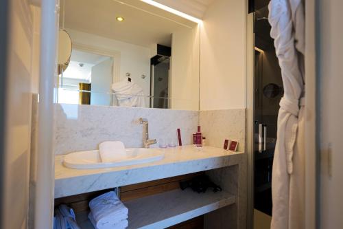 a bathroom with a sink and a mirror at Hôtel Merveilleux Côté Mer in Dunkerque
