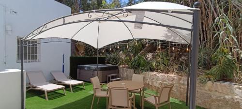 Un patio con una mesa y sillas bajo una sombrilla. en The Red Farm Relais & Spa, en Iklin