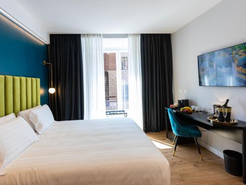 ein Hotelzimmer mit Bett und Schreibtisch in der Unterkunft Regola Luxury Relais in Rom