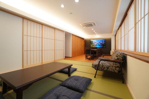 a living room with a table and a chair at Bird Hostel in Kyoto