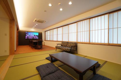 a living room with a table and a tv at Bird Hostel in Kyoto