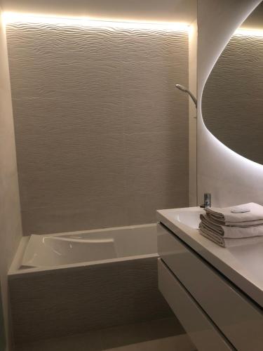 une salle de bain avec une baignoire, un lavabo et un miroir dans l'établissement Logement au calme, à Montpellier