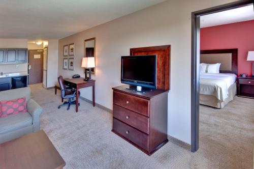 a hotel room with a bed and a flat screen tv at Holiday Inn & Suites Bakersfield by IHG in Bakersfield