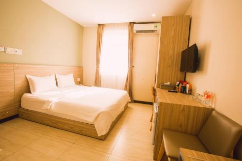 a hotel room with a bed and a television at Mai Vy Hotel Trảng Bàng in Trảng Bàng