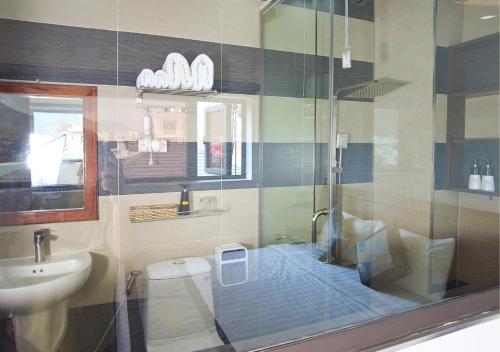 a bathroom with a shower and a toilet and a sink at Sontra Sea Hotel in Danang