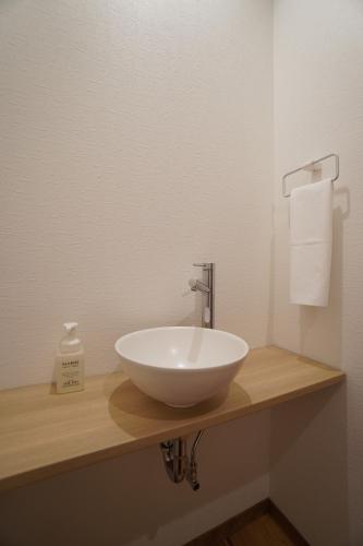 a white bowl sink on a counter in a bathroom at Bird Hostel in Kyoto