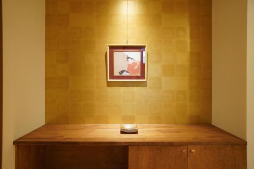 a room with a table with a picture on the wall at Bird Hostel in Kyoto