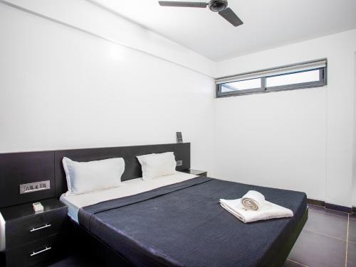 a bedroom with a black and white bed and a window at Crystal Village in Nagoa-Bardez