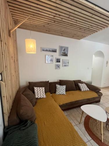 un salon avec un canapé marron et une table dans l'établissement Appartement 5 personnes avec espace plein air, à Saint-Maurice-sur-Moselle