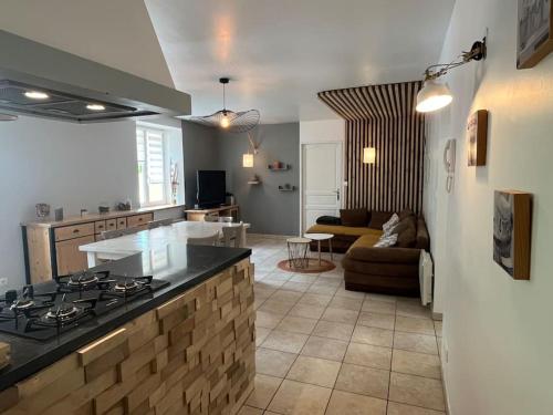 a kitchen and living room with a stove and a couch at Appartement 5 personnes avec espace plein air in Saint-Maurice-sur-Moselle