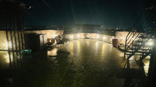 a dark room with a pool of water at night at Riverfront Penthouse Studio with Spacious Terrace in Lucknow