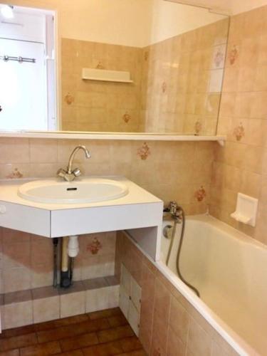 une salle de bain avec un lavabo et une baignoire dans l'établissement Saint-Raphaël Le Salus, à Saint-Raphaël